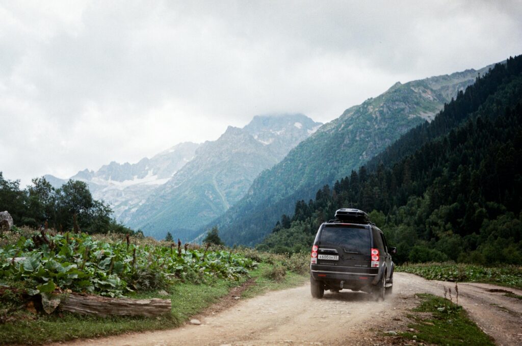 SUV driving on a rugged path through the scenic Caucasus Mountains in Russia.