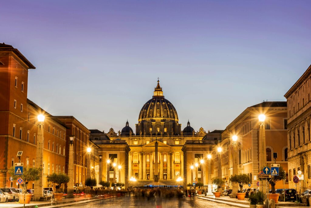 Dramatic view of St. Peter's Basilica illuminated at twilight in Rome.