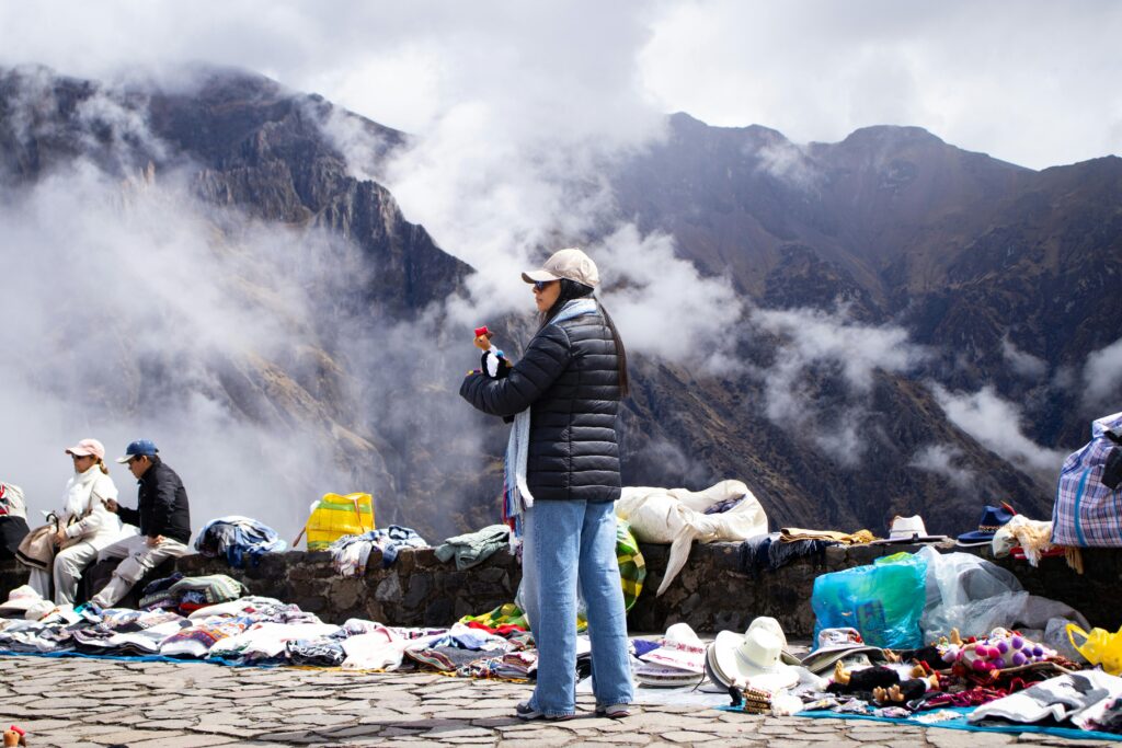 A vibrant street market in the Andes with locals selling colorful souvenirs against a mountain backdrop.