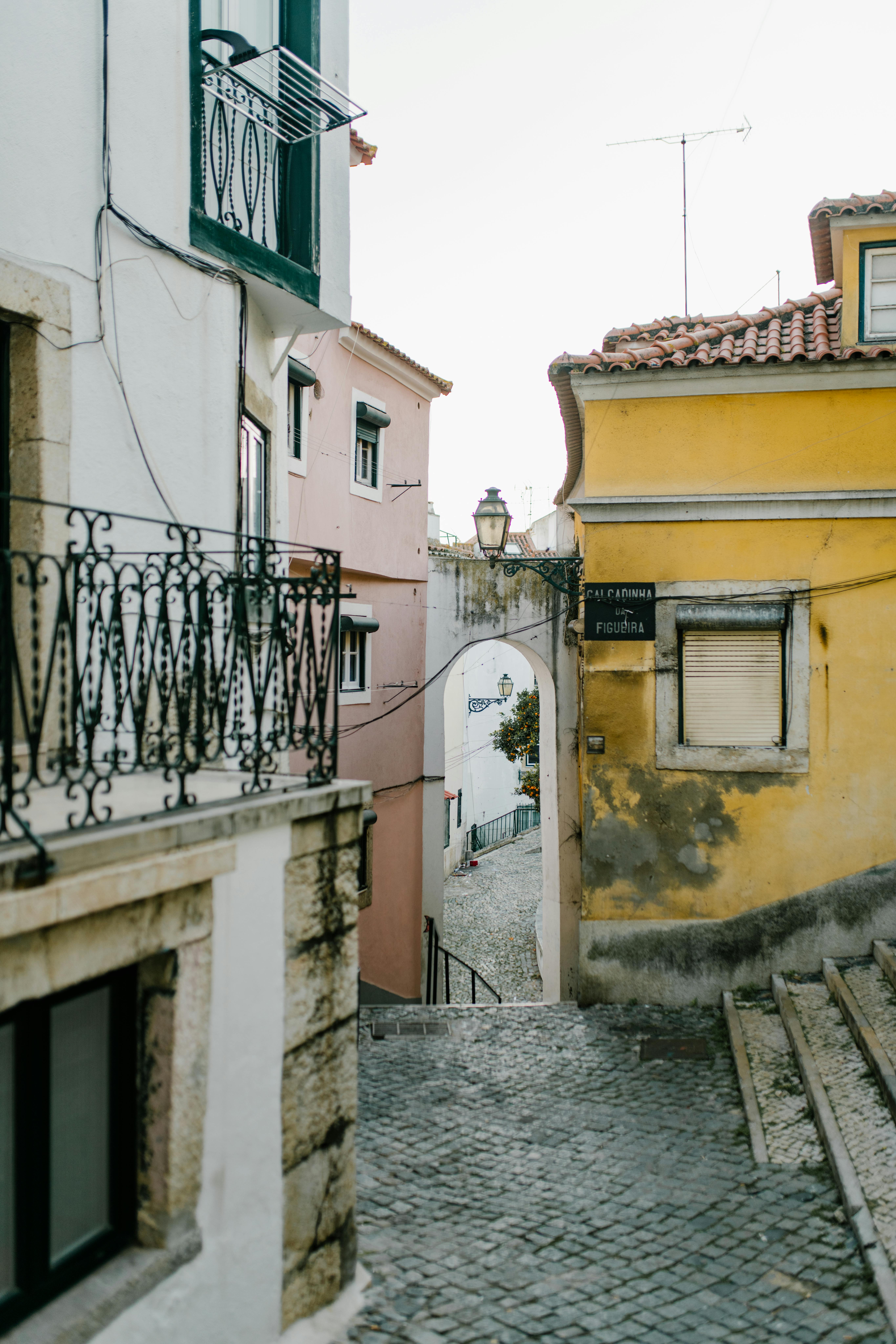 Charming Lisbon street with colorful buildings and cobblestone pathway, showcasing Portugal's architectural style.